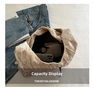 Internal view of champagne pleated bucket bag showing capacity for phone and wallet