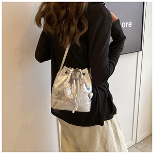 Silver metallic drawstring bucket bag with heart patches shown on model back