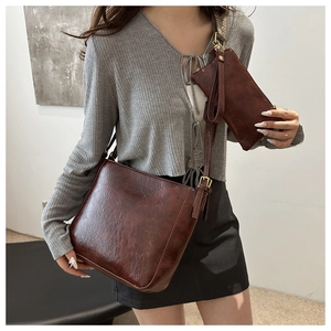 Detail of vintage dark brown faux leather bucket bag with matching inner pouch on model