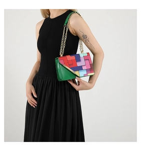 Détails du motif géométrique coloré et de la chaîne dorée sur ce petit sac à bandoulière