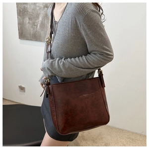 Detail of vintage oil wax leather tote bag with wide jacquard patterned strap and metal buckle