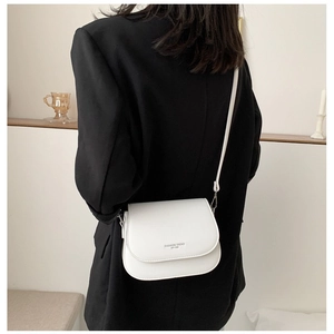 White PU leather saddle bag with fashion trend typography worn over a black blazer