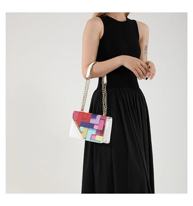 Détail d'un sac à main coloré aux motifs géométriques avec une bandoulière en chaîne dorée