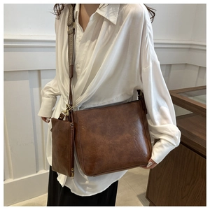 Detail of vintage brown shoulder bag with detachable mini pouch and gold hardware