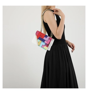 Détail du sac bandoulière en cuir blanc avec rabat géométrique coloré et chaîne dorée