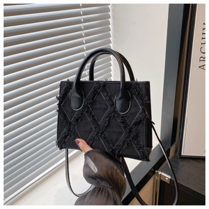 Close-up of black denim tote bag showing unique raw-edged diamond quilted texture details
