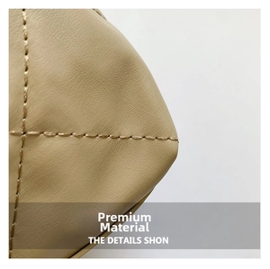 Dettaglio della borsa a secchiello in pelle PU beige con cuciture trapuntate e texture