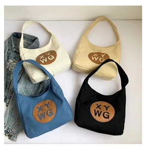 Flat lay of large canvas hobo bags in four colors with leather logo detail