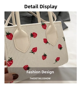 Detailed macro view of strawberry print and white corduroy fabric texture on a tote bag