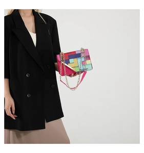 Détail du sac bandoulière aux blocs géométriques colorés avec chaîne dorée sur mannequin