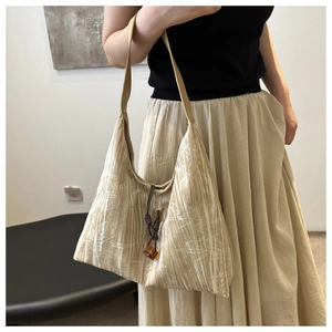 Detail der eleganten Falten-Tragetasche mit Bambusblatt-Textur und Bernstein-Anhänger
