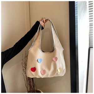 Nahaufnahme der beigen Canvas-Tasche mit fünf bunten 3D-herzförmigen Dekopatches