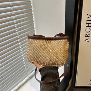 Minimalist woven straw crossbody bag with dark brown leather handles and trim
