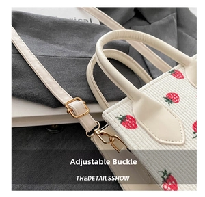 Detail of adjustable metal buckle and strap on strawberry corduroy small square bag