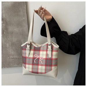 Détail du sac cabas à carreaux avec broderie nœud rose et bandoulière en cuir crème