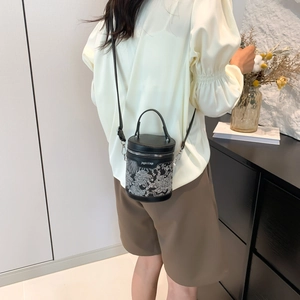 Sac seau cylindrique noir chic avec broderie blanche et bandoulière réglable