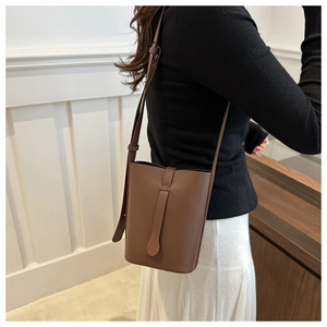 Brown litchi grain bucket bag with adjustable shoulder strap and decorative strap detail