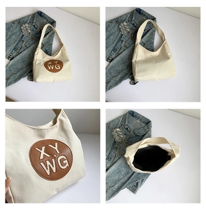 Detail view of large canvas tote bag with brown leather patch and spacious interior