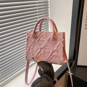 Pink quilted canvas handbag with crossbody strap shown in a soft sunlit interior