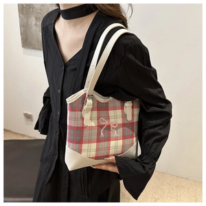 Détail du sac cabas à carreaux avec broderie nœud rose et garniture en cuir blanc sur l'anse