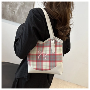 Détail d'un sac cabas à carreaux avec broderie nœud rose et bandoulière en cuir
