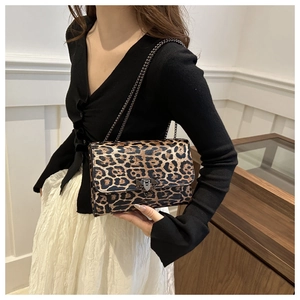 Close-up of leopard print baguette bag with metal chain strap and vintage clasp detail