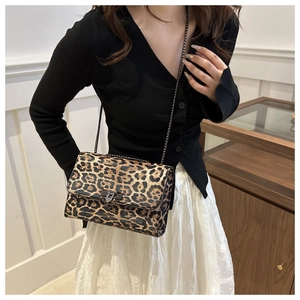 Détail du sac bandoulière léopard avec chaîne métallique et boucle à clous