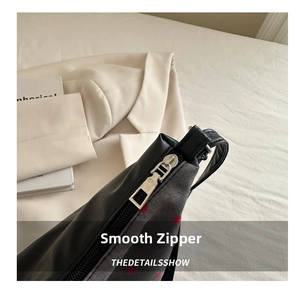 Vue détaillée du zip métallique et du tissu à pois sur le sac fourre-tout élégant