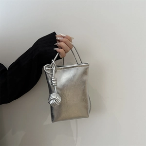 Petit sac bandoulière argenté effet froissé avec pendentif boule tressée élégant