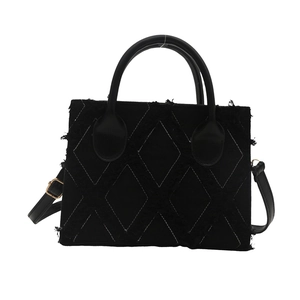 Black canvas tote bag with white contrast stitching and distressed fringe detail