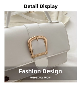 Détail de la boucle métallique dorée en D et du cuir blanc du sac à bandoulière