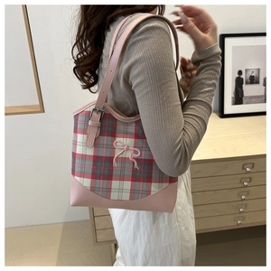 Détail de la texture en tissu écossais rose et du joli nœud sur ce sac fourre-tout