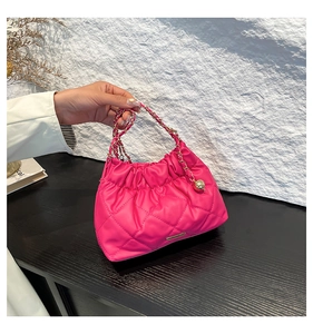 Dettaglio borsa a tracolla trapuntata magenta con catena dorata e design a pieghe nuvola