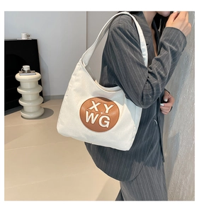 Detail of white canvas shoulder bag with brown leather XY WG letter patch logo
