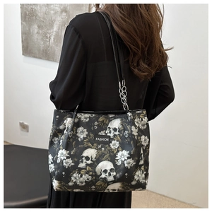 Détail du cabas noir avec imprimé tête de mort et fleurs et étiquette en cuir mode