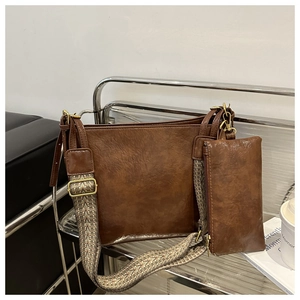 Detailed view of vintage brown bucket bag with bohemian strap and matching mini pouch