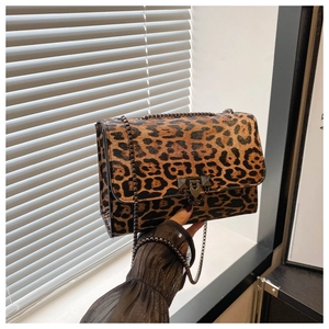 Détail du sac léopard avec bandoulière en chaîne dorée et fermoir métallique