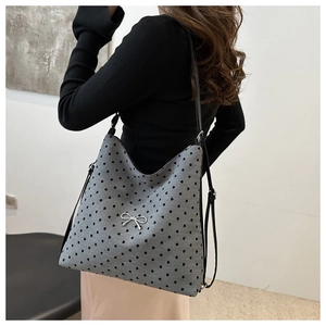 Détail du sac cabas gris à motifs de cœurs avec breloque nœud argenté