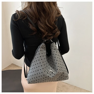 Détail du sac fourre-tout gris avec motifs de cœurs noirs et boucle nœud en métal