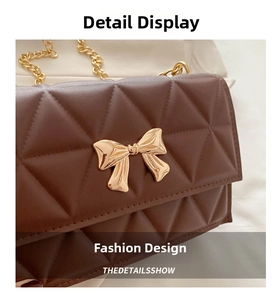 Close-up of diamond-quilted brown leather bag with a golden bow-shaped metal clasp