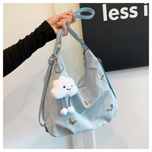 Détail du sac en nylon bleu clair avec papillons argentés et pendentif nuage en peluche