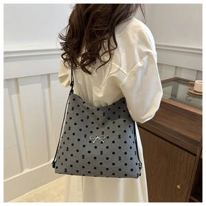 Détail du sac cabas gris à pois avec un nœud argenté et une fine bandoulière noire