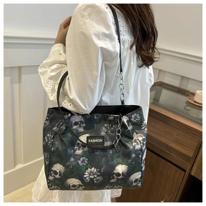 Détail du sac cabas à imprimé tête de mort et fleurs avec bandoulière en chaîne