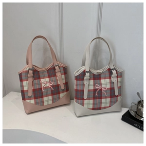Sacs cabas en toile à carreaux avec nœuds roses et garnitures en cuir sur fond moderne