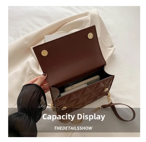 Detailed interior of quilted brown crossbody bag showing storage space and gold chain strap