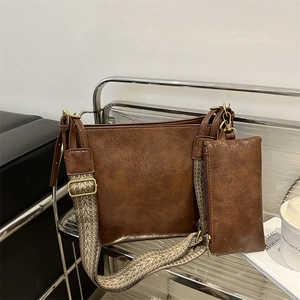 Retro brown leather tote bag with wide jacquard strap and small matching pouch on a cart