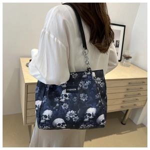 Détail du sac cabas à imprimé fleurs et crânes avec chaîne et lanière en cuir