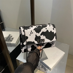 Sac bandoulière chic à motif vache avec chaîne en métal et fermeture à rabat épurée