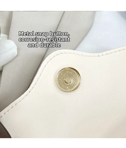 Macro shot of gold magnetic clasp and precise stitching on retro white leather bag