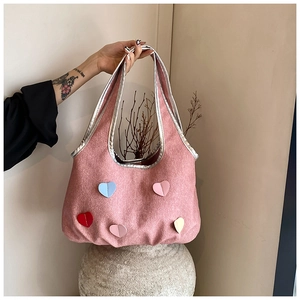 Detail der rosa Canvas-Tasche mit bunten 3D-Herzapplikationen und glänzendem Besatz
